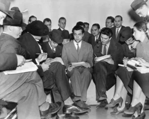 Photo of Orson Welles (center) meeting with reporters after the War of he Worlds radio broadcast. Welles tried to explain that he and his theater company had no idea the broadcast would cause panic.